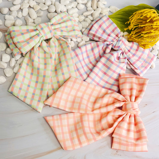 Plaid headbands in pastel colors on a stone surface