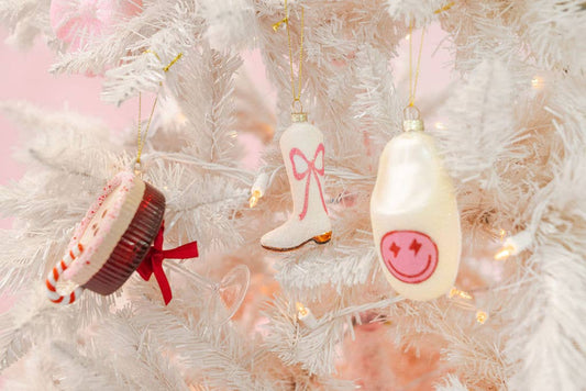 Decorative Christmas ornaments on a white tree with pink accents