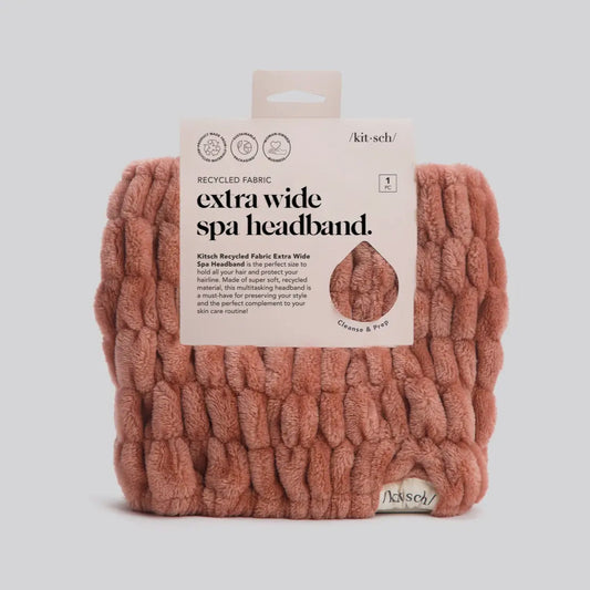 Pink knitted spa headband with packaging on a light gray background