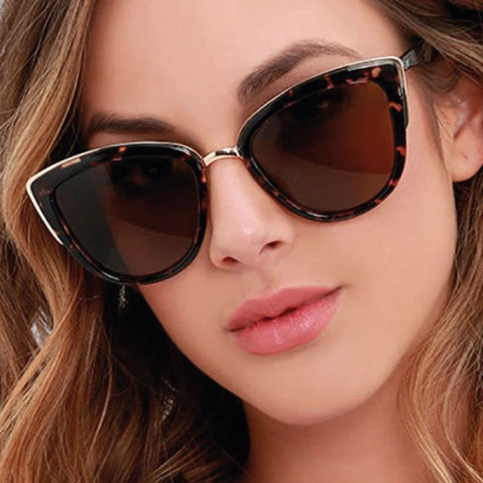 Close-up of a woman wearing tortoiseshell cat-eye sunglasses with a blurred background