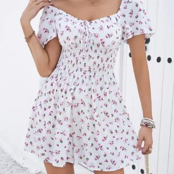 Woman wearing a white floral dress with a plain background