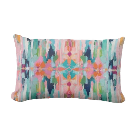 A rectangular lumbar throw pillow featuring a vibrant, symmetrical abstract watercolor pattern in pink, teal, green, orange, and navy on a light gray background.