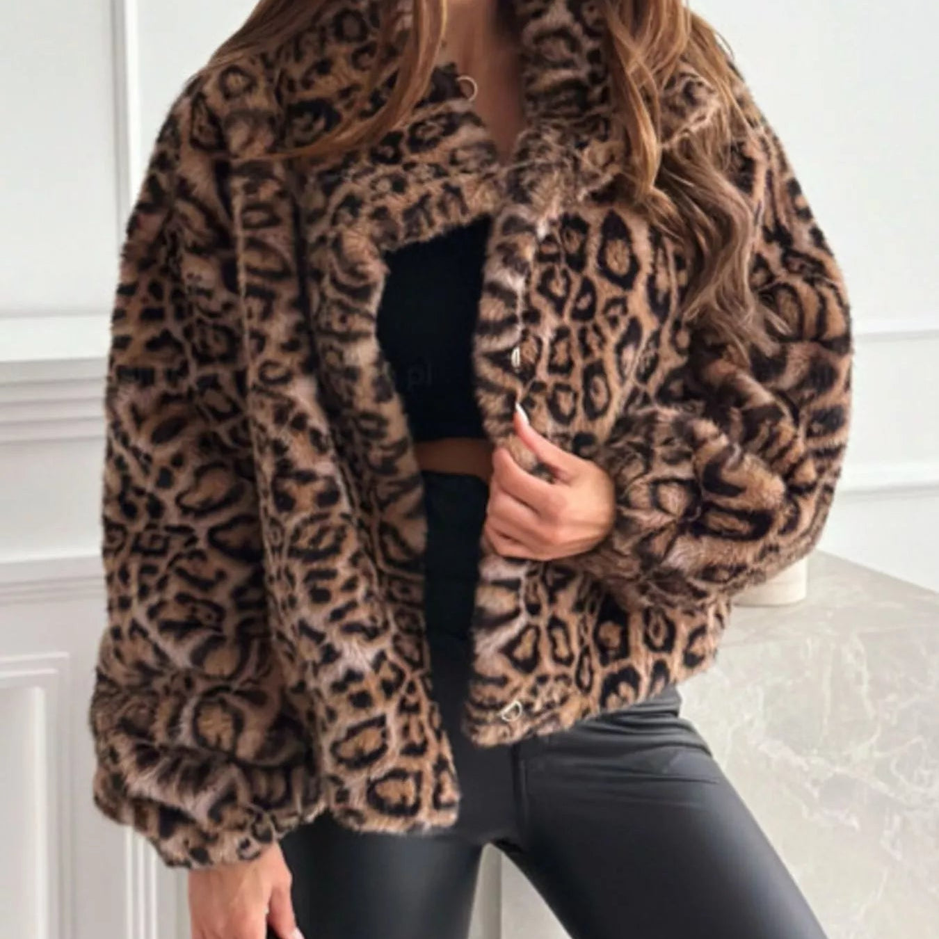 Person wearing a leopard print coat with a neutral background