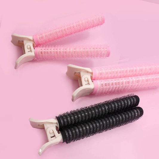 Set of hair rollers with pink and black designs on a pink background