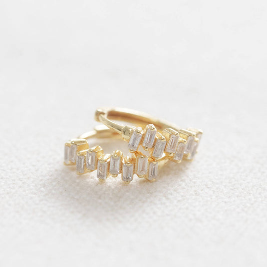 Gold and silver hoop earrings on a light gray background