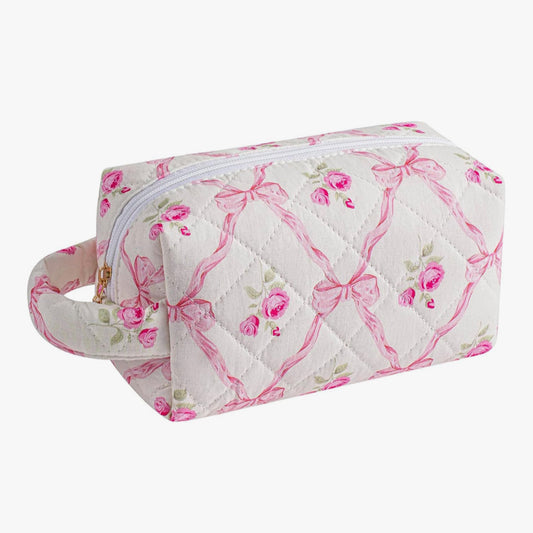 Quilted toiletry bag with pink bows and floral patterns on a white background