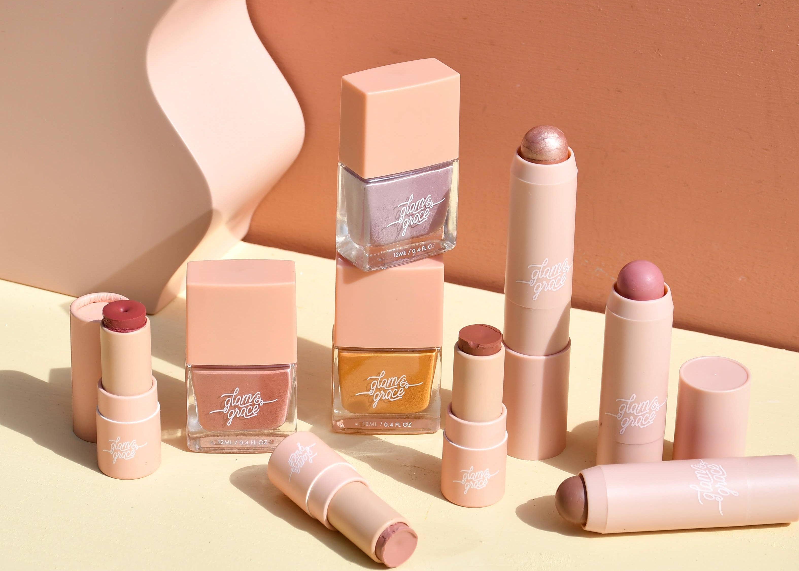 Collection of lip products including lipsticks and a nail polish on a gradient background