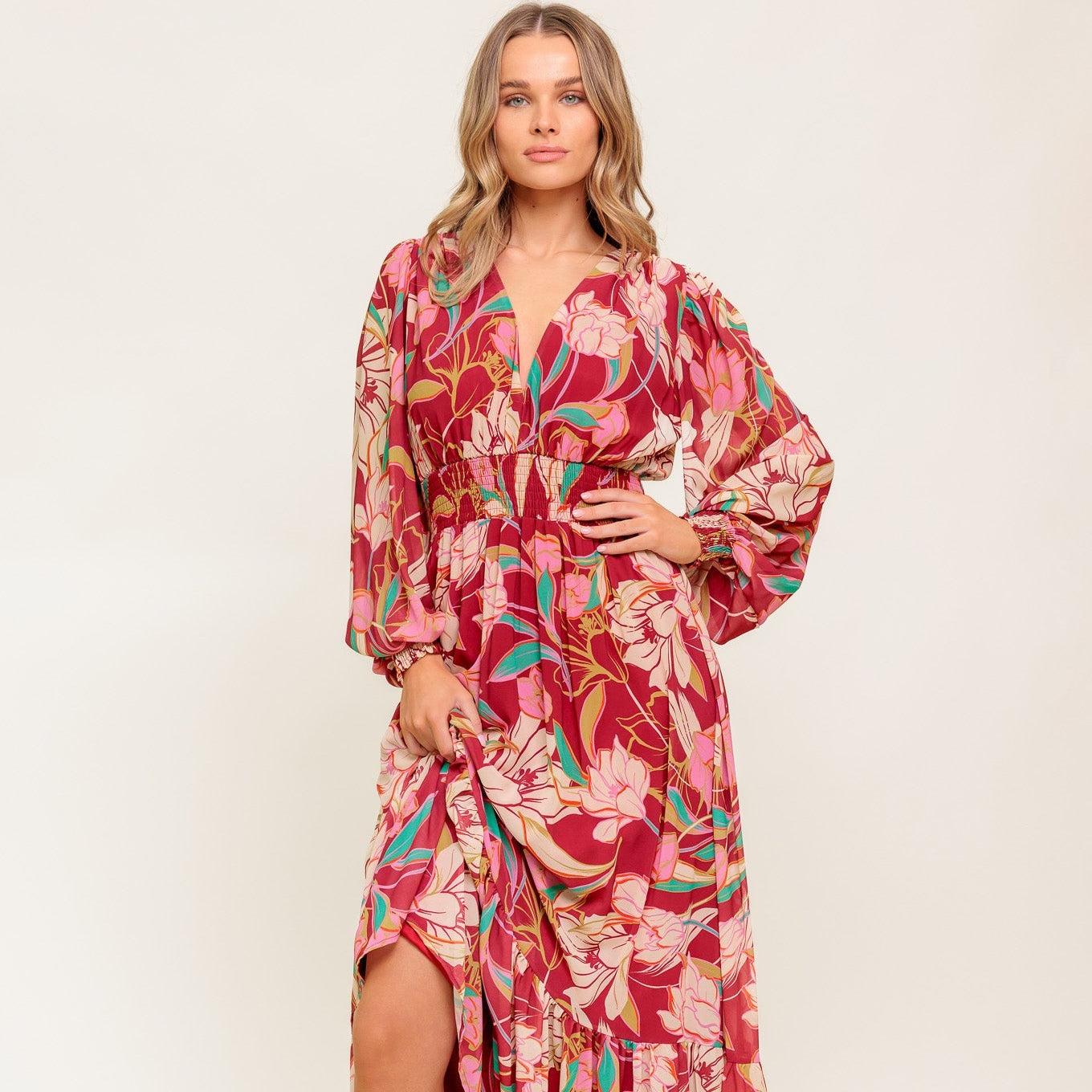 Woman wearing a red floral dress on a white background