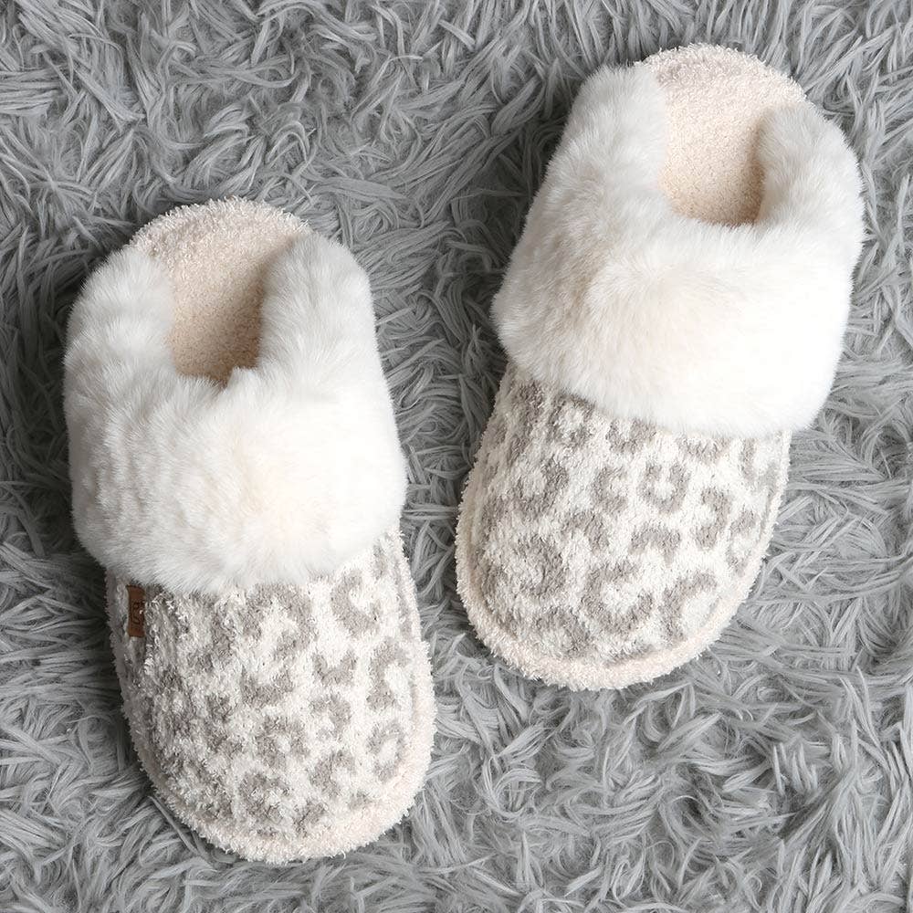 Pair of white slippers with leopard print soles on a gray textured surface