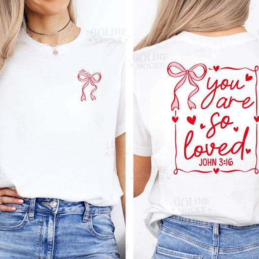 Two people wearing white t-shirts with red graphics and text, one featuring a bow and the other 'you are so loved' with a Bible verse.
