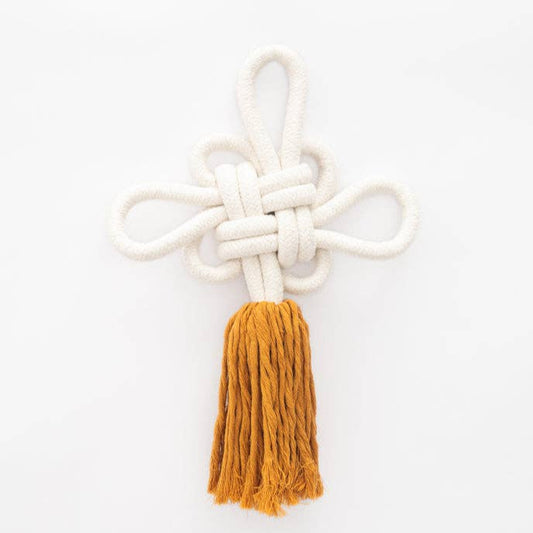 White knotted rope with a mustard yellow tassel on a white background