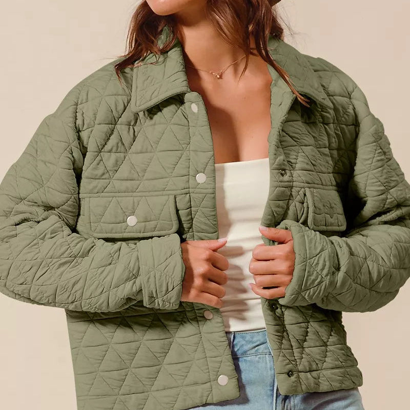 Woman wearing a green quilted jacket and beige hat against a beige background
