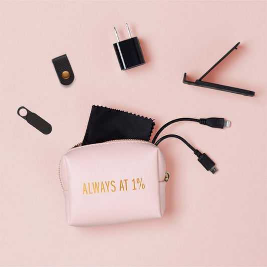 Pink travel accessory pouch with electronic items on a pink background